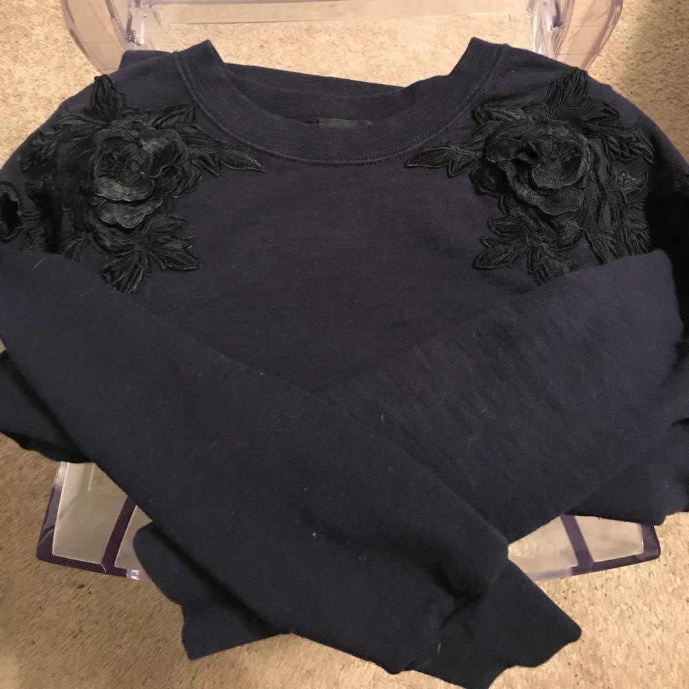 Navy sweatshirt with black followers on shoulders